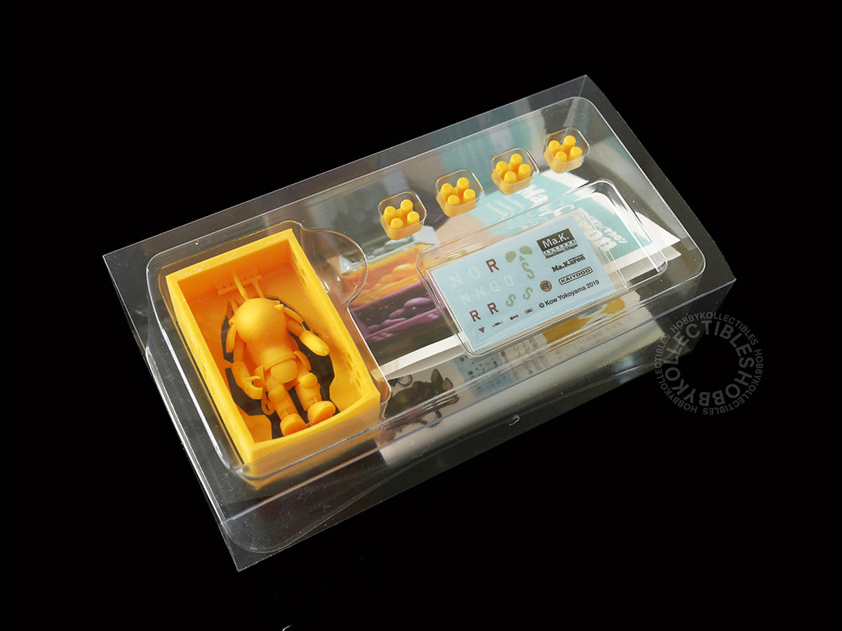 Four third view of a  packaged 3D-printed Kaiyodo Ma.K 1/72 scale Ma.Karon version SAFS kit Fire Ball SG Orange color figure set in clear plastic blister packaging on a black background. The set includes a small Orange SAFS figure, four hexagonal studs, printed instruction manual and decals sheet.